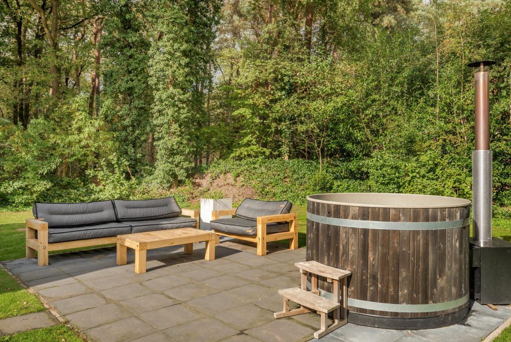 The lovely hot tub in the garden surrounded by woods.