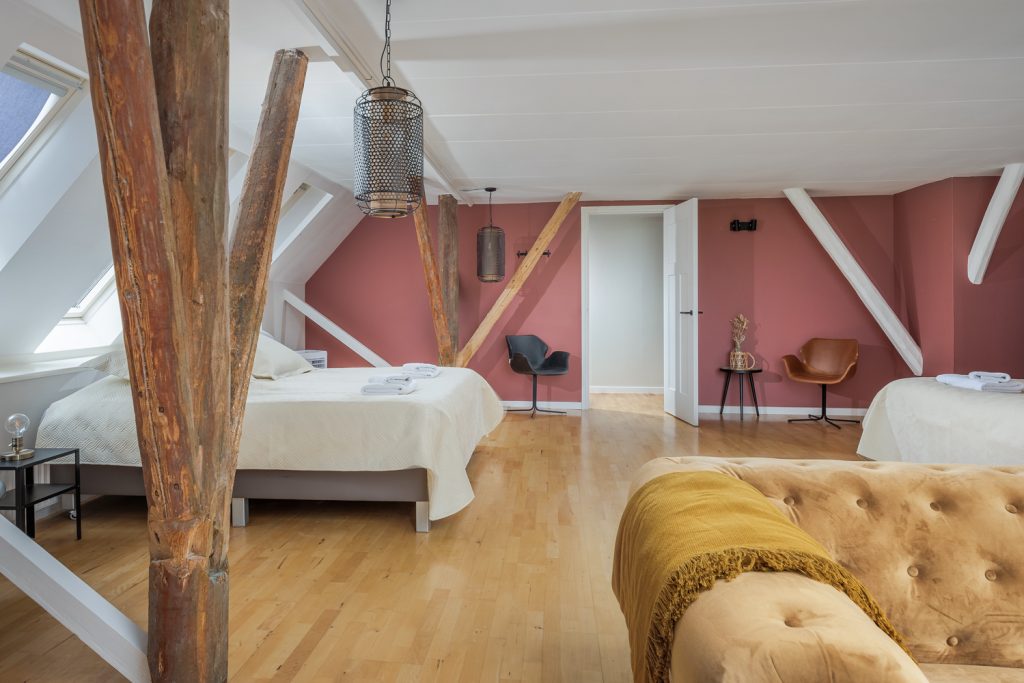Een van de luxe en ruime slaapkamers waar de houten palen die zijn overgebleven van de oude boerderij prachtig zijn geïntegreerd in de kamer waardoor het karakter is behouden. Deze luxe villa in Nederland kunt u bij Golden Stay huren! 